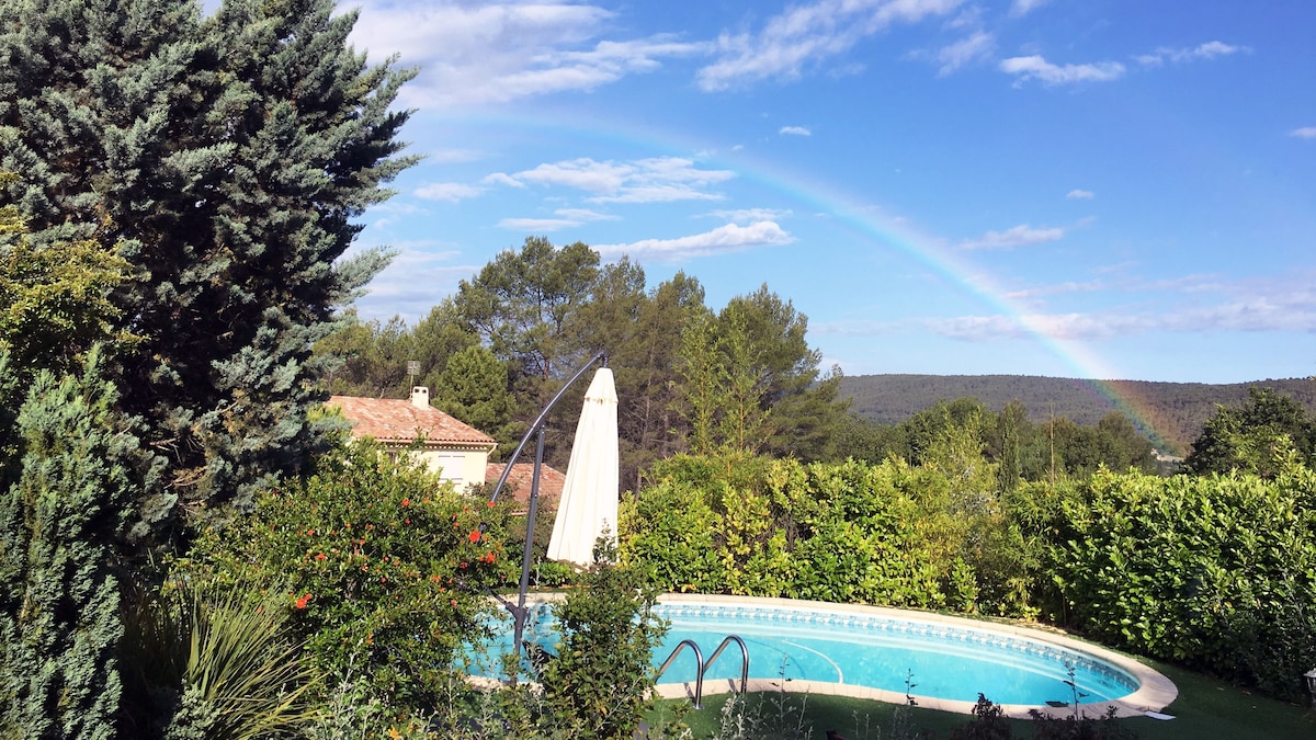 Piscine et arc-en-ciel sur les collines